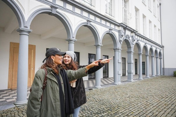 Zichtbaar ontroerd wijzen ex-leerlingen Steffi en Sarah op de binnenplaats naar de plek waar ze ooit les kregen. 